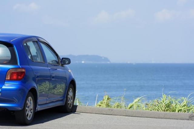 海辺に停車したコンパクトカー