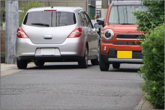 狭い路地で2台の車がすれ違う様子