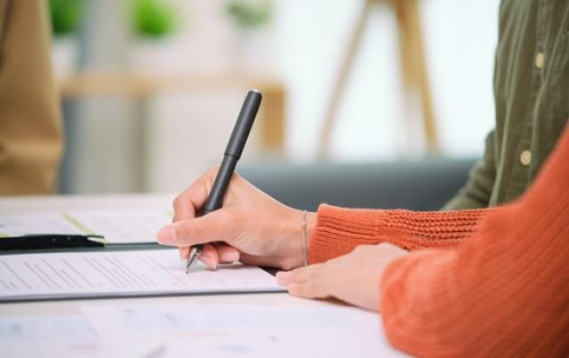 書類を記入する女性の手元