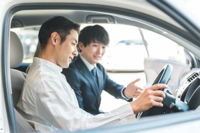 納車された車に乗る男性