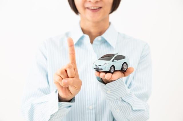 ミニカーを持ってアドバイスを促す女性