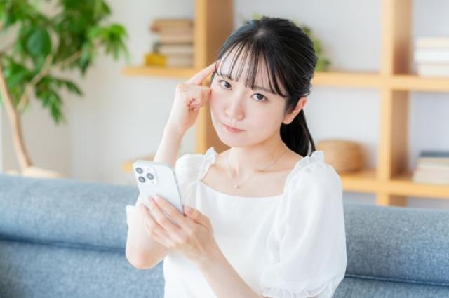 スマホ検索しながら考える女性