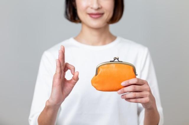財布を持ってOKサインを出す女性