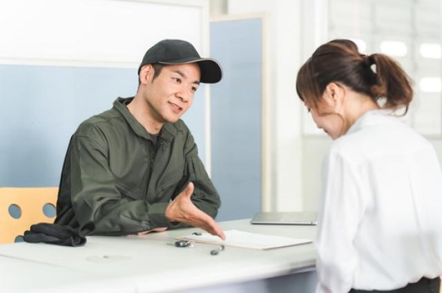 整備工場の受付で見積もりをする整備士
