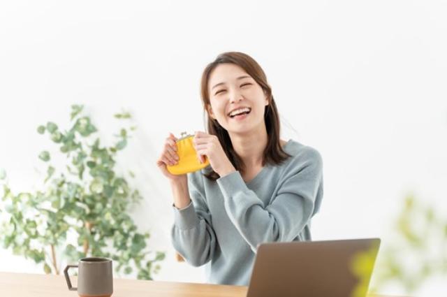 財布を持って喜ぶ女性
