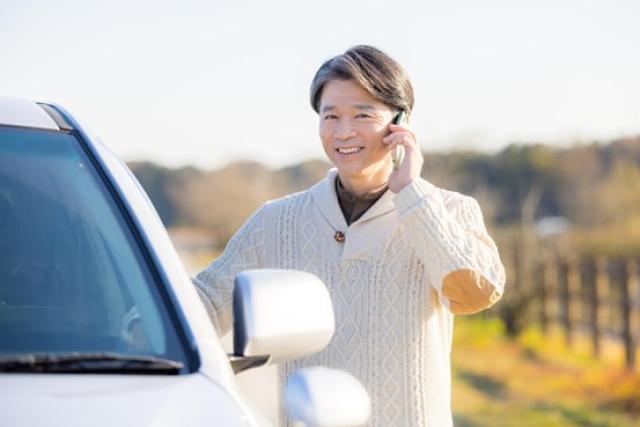 車を降りて電話する男性