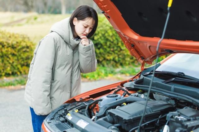車が故障して悩んでいる女性
