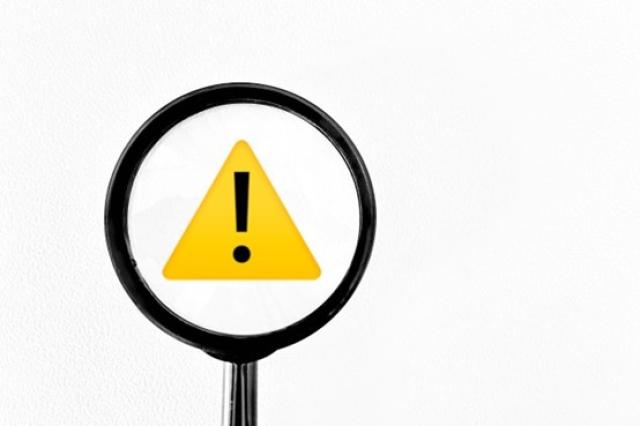 虫眼鏡でコーションマークを拡大する様子