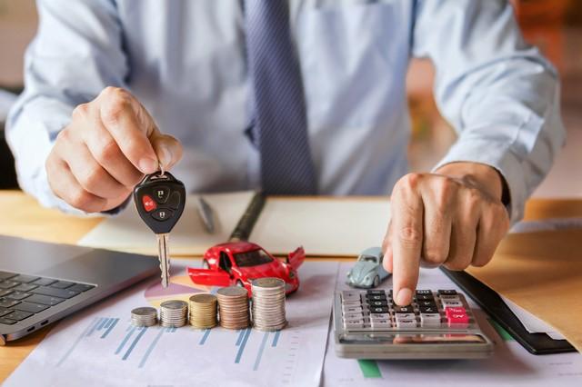 車のキーを持った人が電卓で計算する様子
