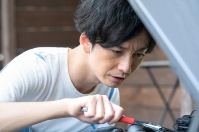 自力で車両整備をする男性