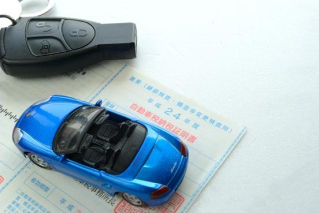 自動車税納税証明書と青い車の模型