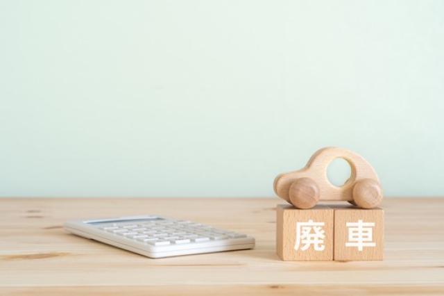 廃車と書かれたブロック、電卓、車のおもちゃ