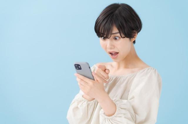 スマホを見て驚く女性