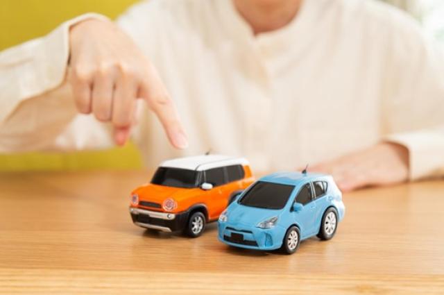 ミニカーを指差す人