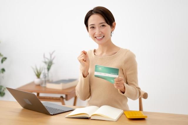 通帳を持ってガッツポーズする女性