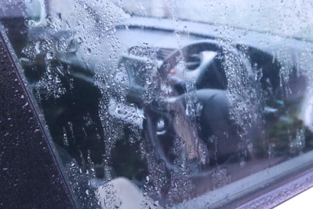 雨でぬれる運転席の窓