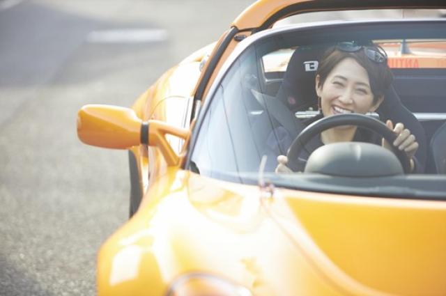 オープンカーで夏をエンジョイする女性
