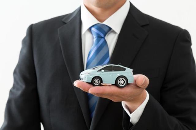 ミニカーを持つビジネスパーソン