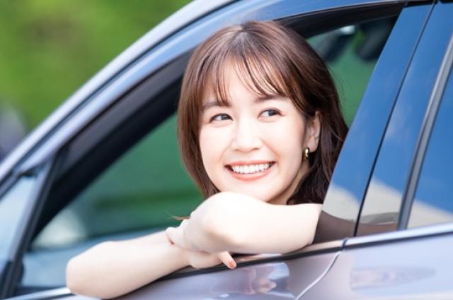 車から顔を出す笑顔の女性