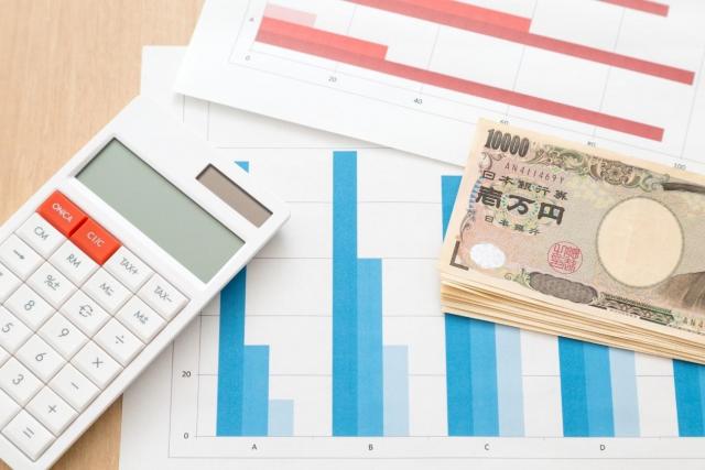 棒グラフが書かれた紙と、電卓と紙幣