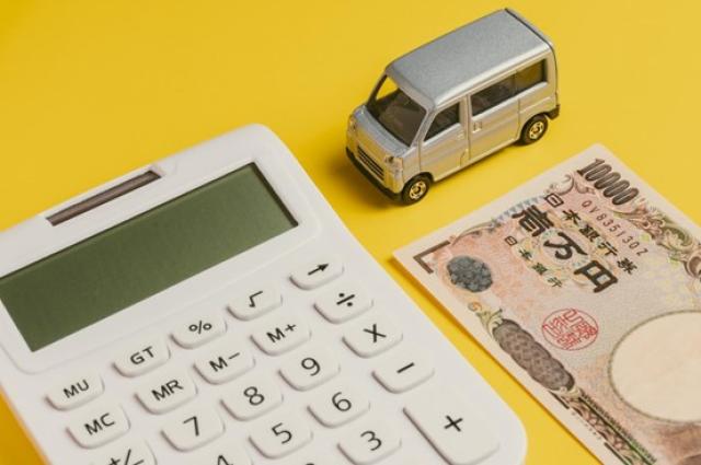 軽自動車のミニカーと電卓、お金