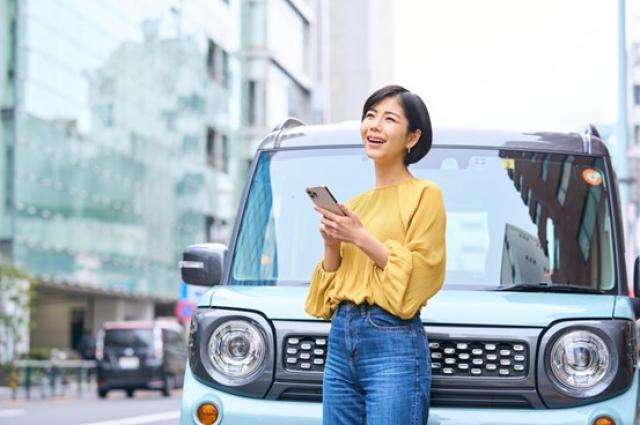 車とスマホを触る女性