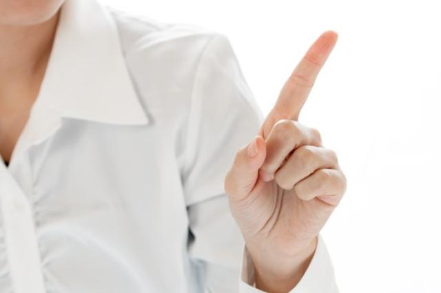 人差し指を立てる女性の手
