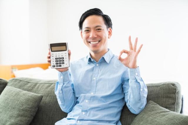 電卓を持つ笑顔の男性