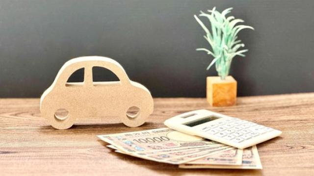 車の模型と電卓、現金