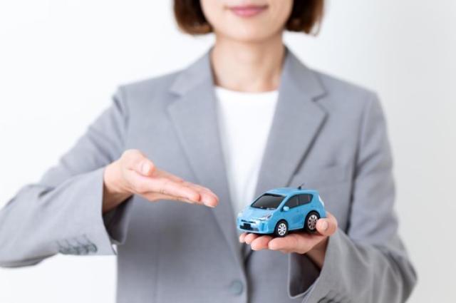 ミニカーを持っておすすめする女性