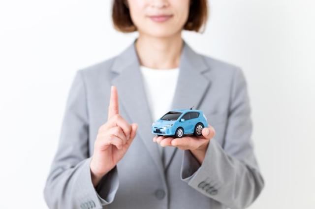 ミニカーを持ってアドバイスを促す女性