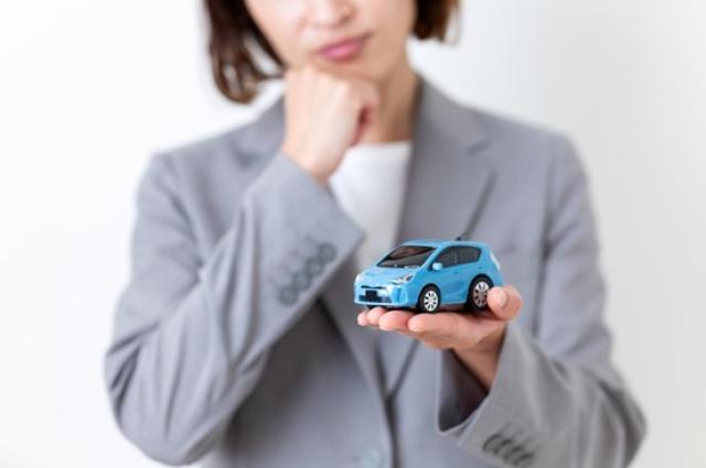 ミニカーを持って考える女性