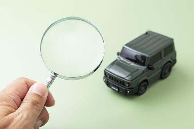 虫眼鏡で自動車を観察する手元