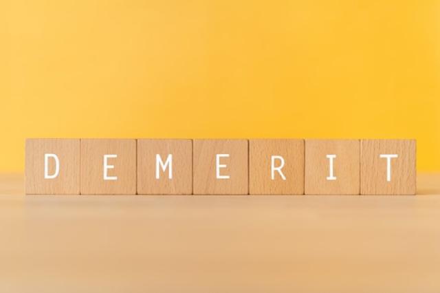 「DEMERIT」と書かれた積み木
