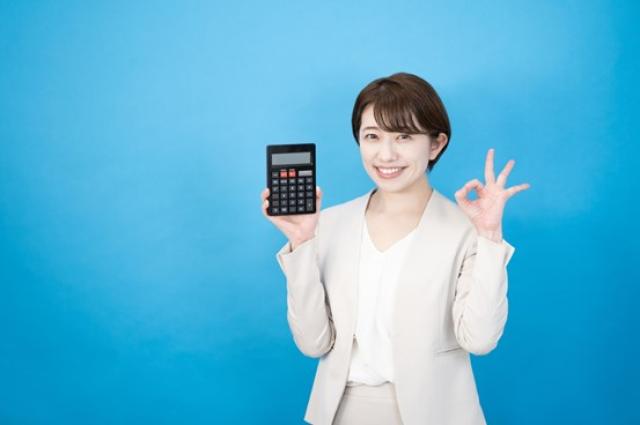 電卓を持って微笑む女性