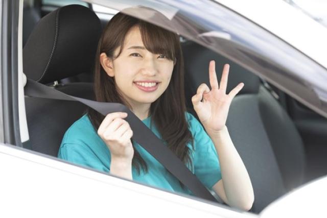 車内でOKサインを出す女性