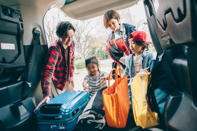 トランクに荷物を積み込む家族