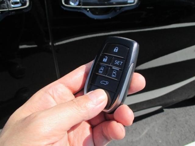 車のスマートキーを持つ手