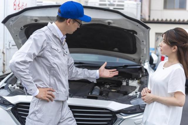 車のメンテナンスを受ける女性