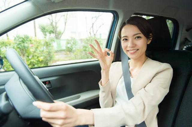 車内でOKサインを出す女性