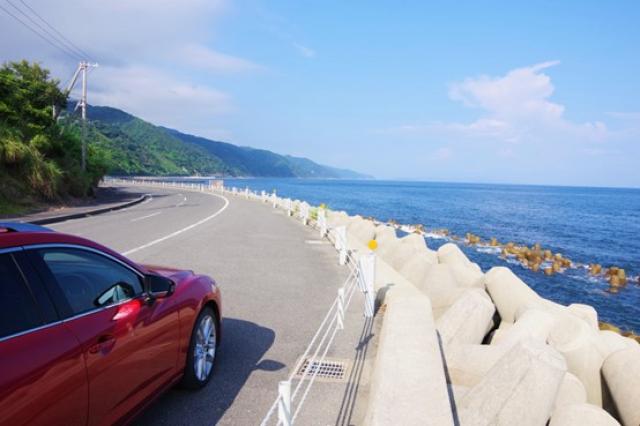 海沿いに駐車した赤い車