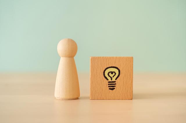 木製の人型オブジェと電球が描かれた積み木