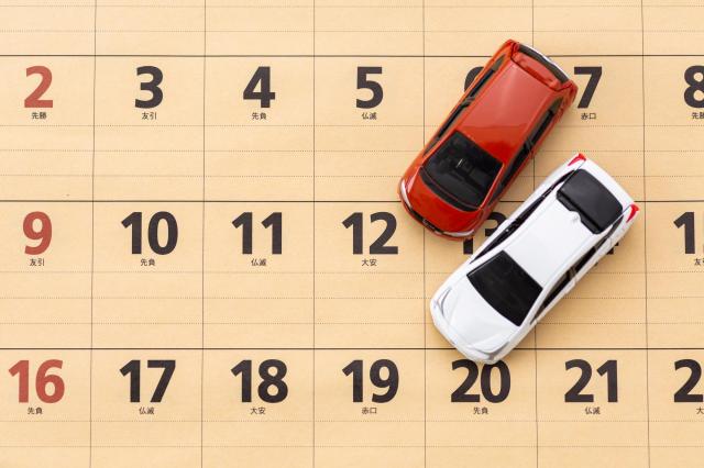 カレンダーの上に置かれた2つのミニカー