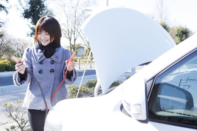 ブースターケーブル接続をする女性