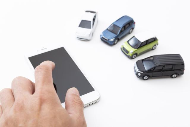 ミニカーとスマホを触る手