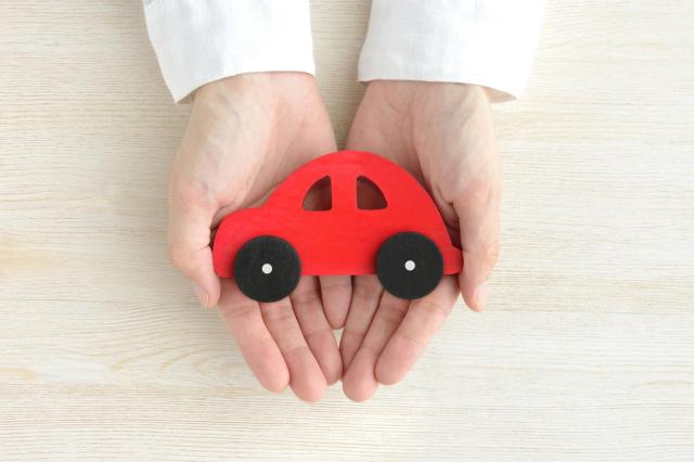 手の上に乗せられた車のおもちゃ