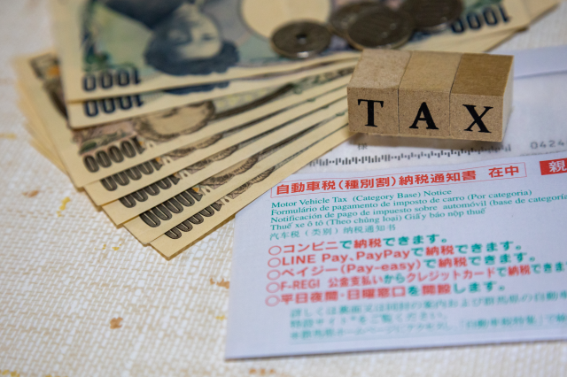 自動車税納税通知書と紙幣、TAXのブロック