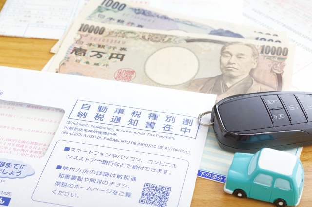 自動車税納税通知書と紙幣、ミニカー、スマートキー