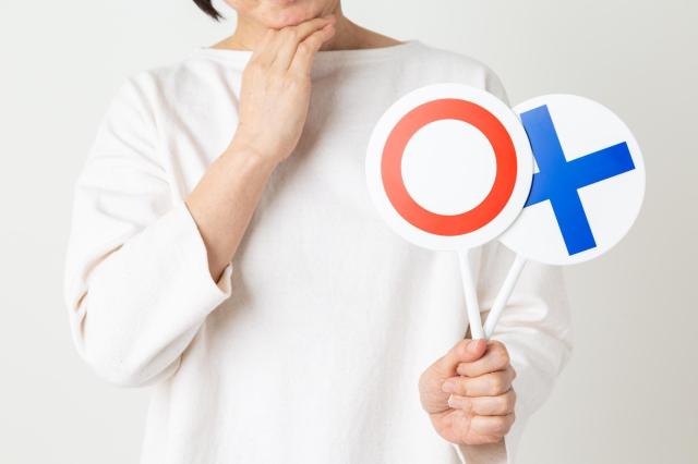 丸バツのプレートを持った人