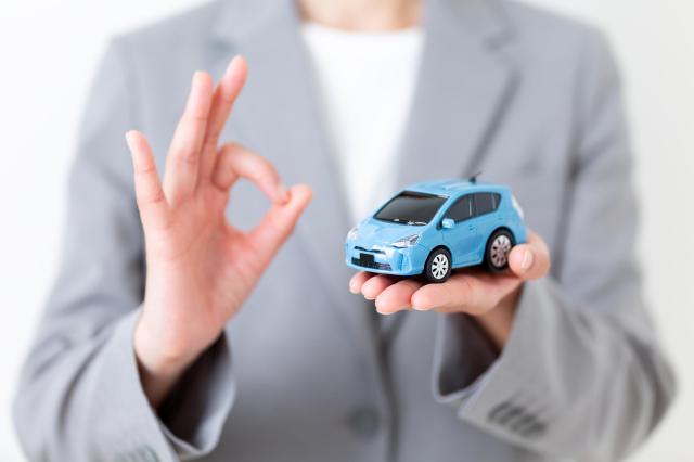 ミニカーを持ってOKサインをする人